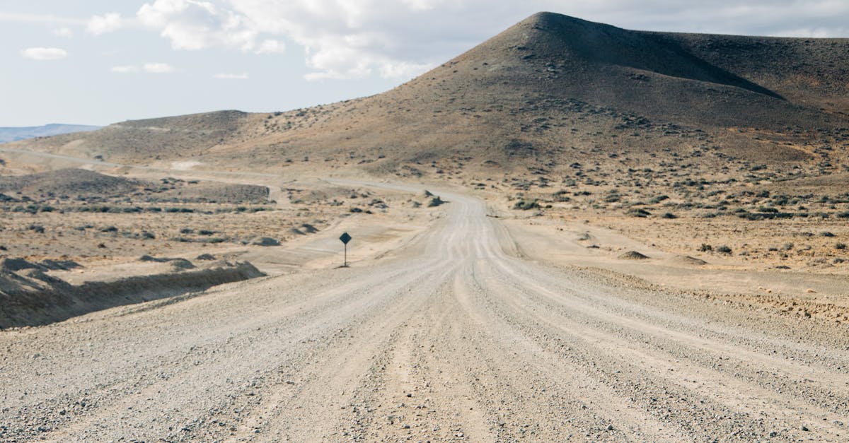 Long dirt road under blue sky in an arid landscape