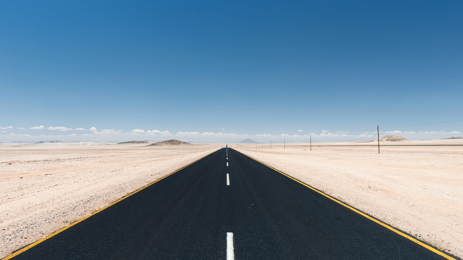 Empty gravel road running through the Namib Desert on the way toward the coast